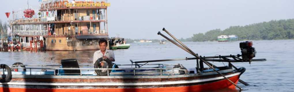 Traditional boat sailing on the Mekong River during an active shore excursion